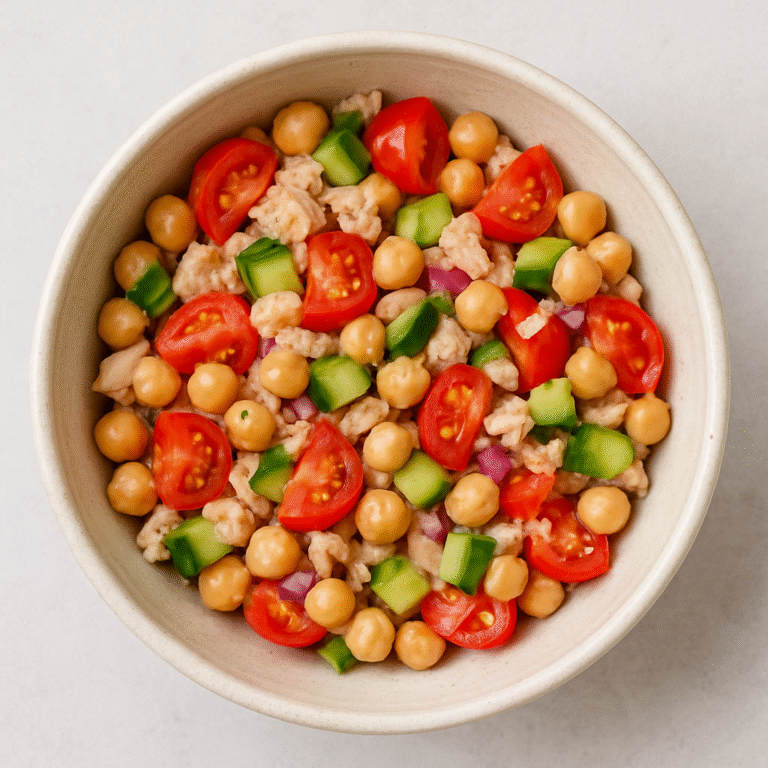 Chickpea tuna salad in a bowl with cherry tomatoes, cucumber, red onion, and herbs — a quick, healthy no-cook meal for solo living