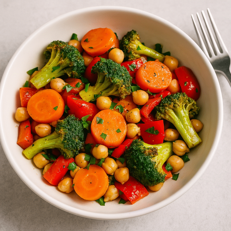 Warm salad with sautéed vegetables served in a bowl, featuring broccoli, peppers, tomatoes, and lightly wilted greens.